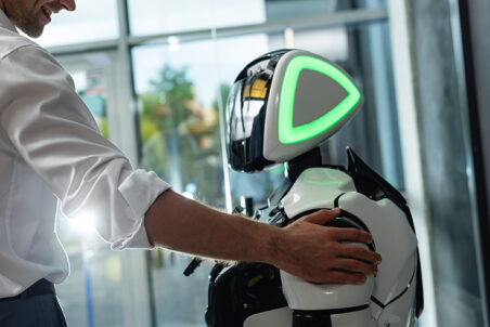 Man putting his hand on a robot's shoulder