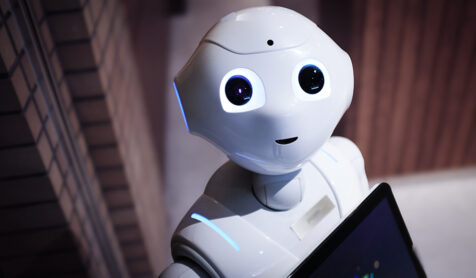 A white, round robot with a smiling expression. The robot's features include a spherical body, two small eyes, and a curved line representing a cheerful smile.